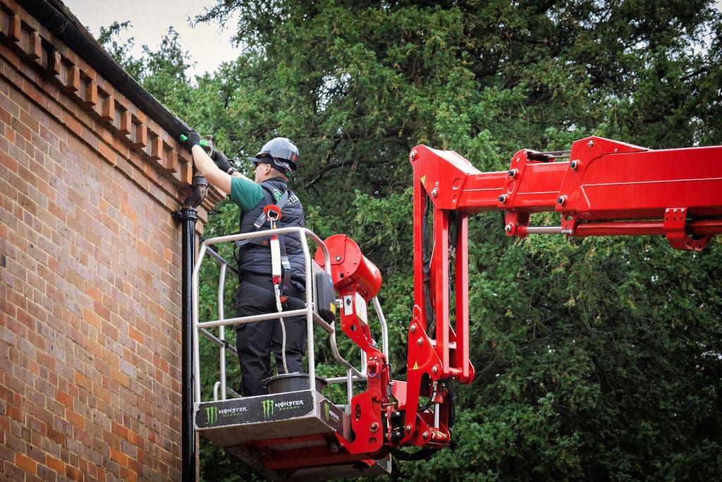 PP Gutters carrying out gutter cleaning and maintenance on a cherry picker, in West Wickham
