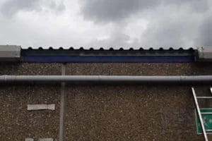 PP Gutters commercial roof and gutter cleaning services. Showing a damaged commercial gutter before being repaired.