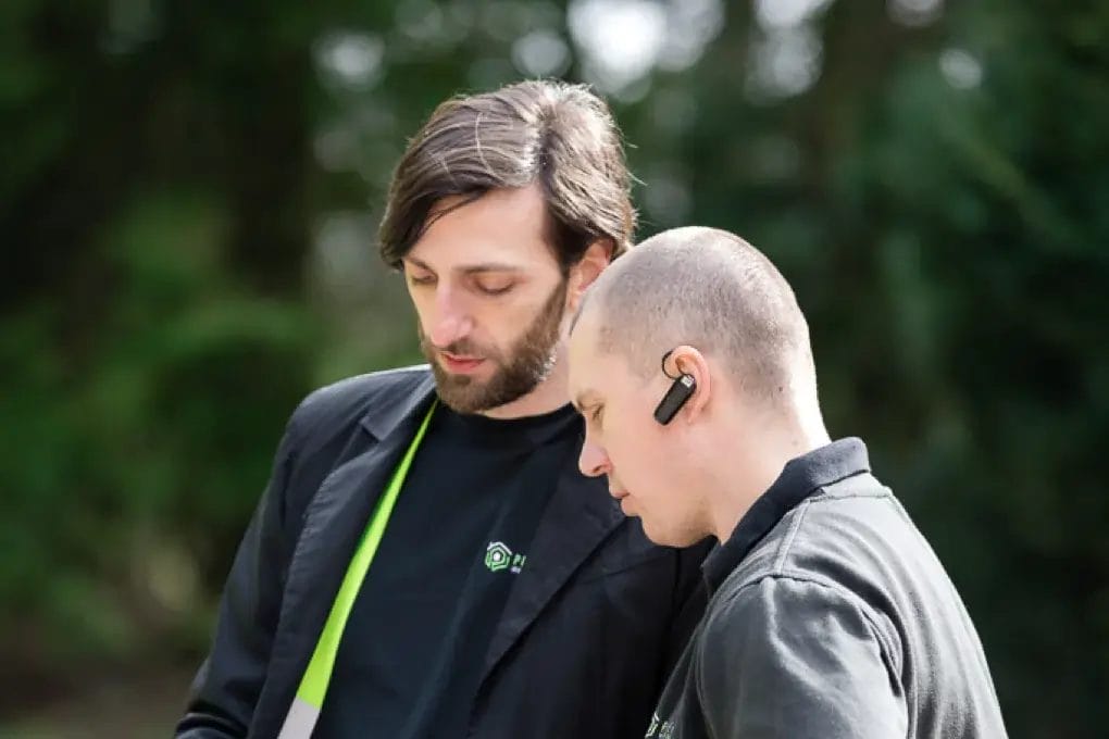PP Gutters roof and gutter cleaning services. Team members discussing a project.