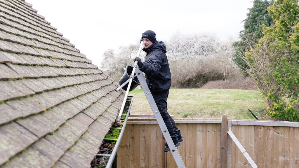 PP Gutters residential roof and gutter cleaning services. Showing a residential property's gutter being cleared.