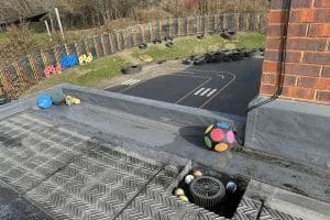 School gutter and roof clearing in London, Watford and High Wycombe - photo of a flat roof with built in gutter at St Mary's CofE School in Aylesbury, before it's been cleared of sports balls and debris by PP Gutters.