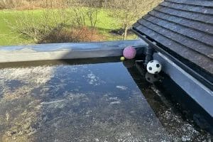 School gutter and roof cleaning in London, Watford and High Wycombe - photo of a flat roof at St Mary's CofE School in Aylesbury, flooded due to blocked gutters.