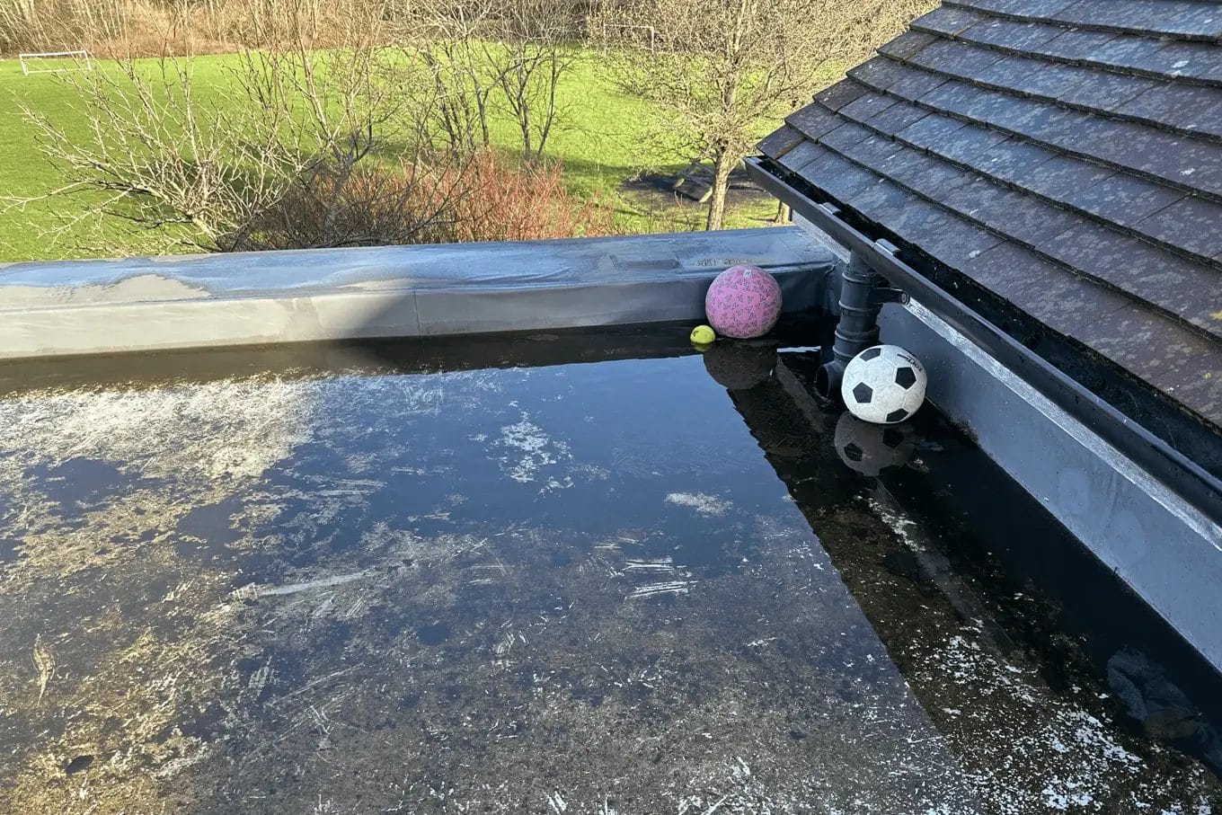 School gutter and roof cleaning in London, Watford and High Wycombe - photo of a flat roof at St Mary's CofE School in Aylesbury, flooded due to blocked gutters.