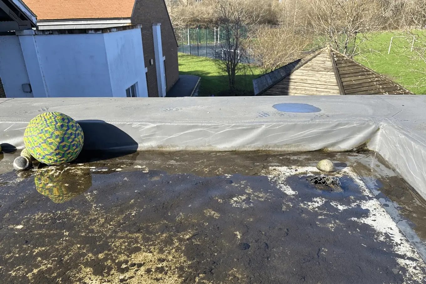 School gutter and roof cleaning in London, Watford and High Wycombe - photo of a flat roof at St Mary's CofE School in Aylesbury, flooded due to blocked gutters.