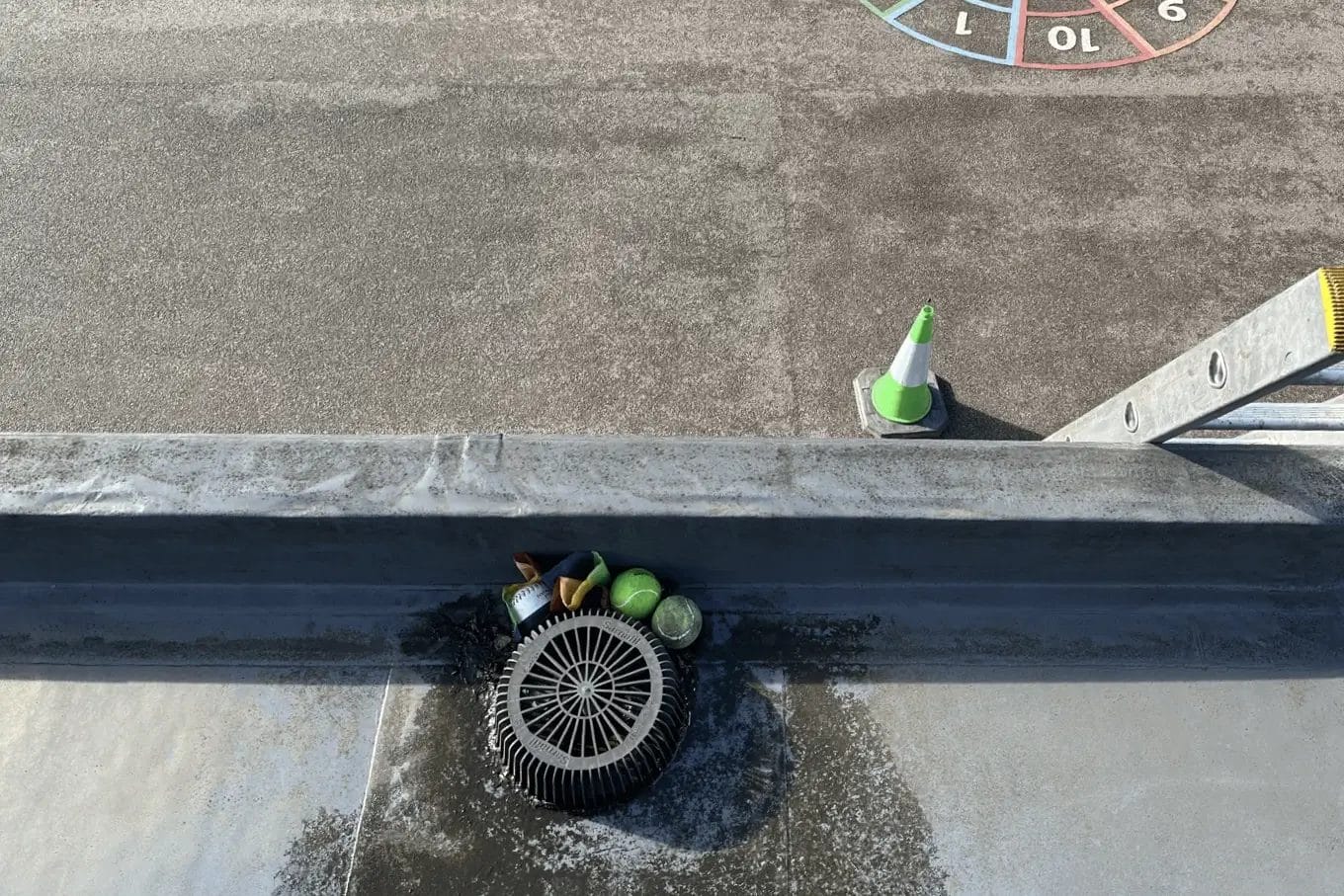 School gutter and roof clearing in London, Watford and High Wycombe - photo of a flat roof with built in gutter at St Mary's CofE School in Aylesbury, before it's been cleared of various balls and debris by PP Gutters.