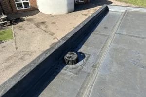 School gutter and roof clearing in London, Watford and High Wycombe - photo of a flat roof with built in gutter at St Mary's CofE School in Aylesbury, after it's been cleared of various balls and debris by PP Gutters.