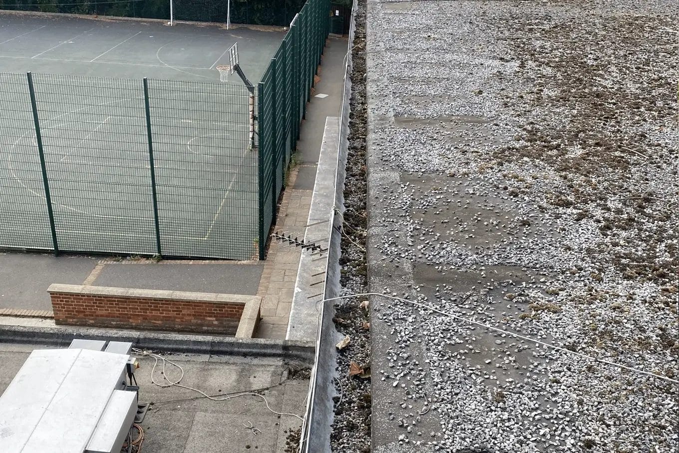School gutter and roof cleaning in London, Watford and High Wycombe - photo of a flat roof and gutter before it's been cleared of debris by PP Gutters.